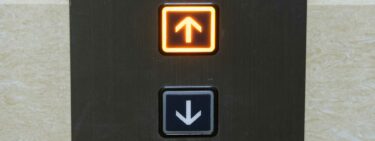 Image of the call button for an elevator, with the up button lit