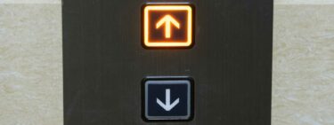 Image of the call button for an elevator, with the up button lit